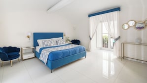 Un dormitorio con una cama grande, una mesita de noche, una silla y un aparador.