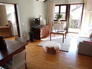 Cozy living space with a dining area, seating area, and large window with curtains.