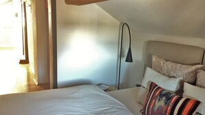 A bedroom with a bed, a bedside table, a lamp, and a window. - Gemütliche Whg. mit Balkon und Bergblick im Oberallgäu! Ruhig und Zentrumsnah (Immenstadt im Allgäu)