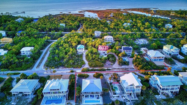 An aerial view of a coastal residential area with houses, a road, and a beach access point. - Brand New Construction, 4 BR Private Pool Plantation Home (ST GEORGE ISLAND)