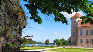 Un lac paisible où se reflètent un bâtiment et des arbres.