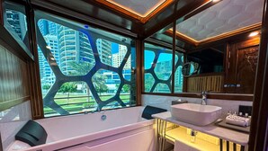 Ein modernes Badezimmer mit einer großen Badewanne, einem Waschbecken und einem Spiegel.