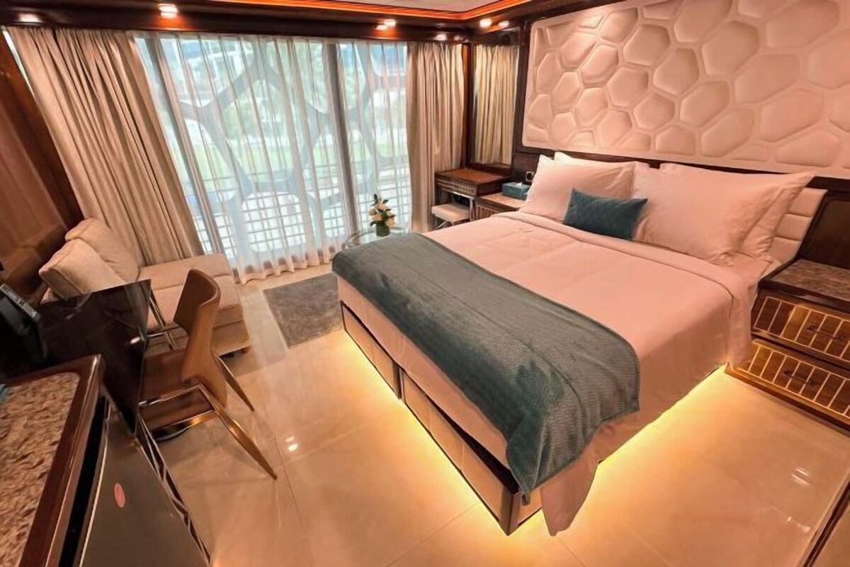 Ein modernes Hotelzimmer mit einem großen Bett, einem Schreibtisch und einem Sessel.