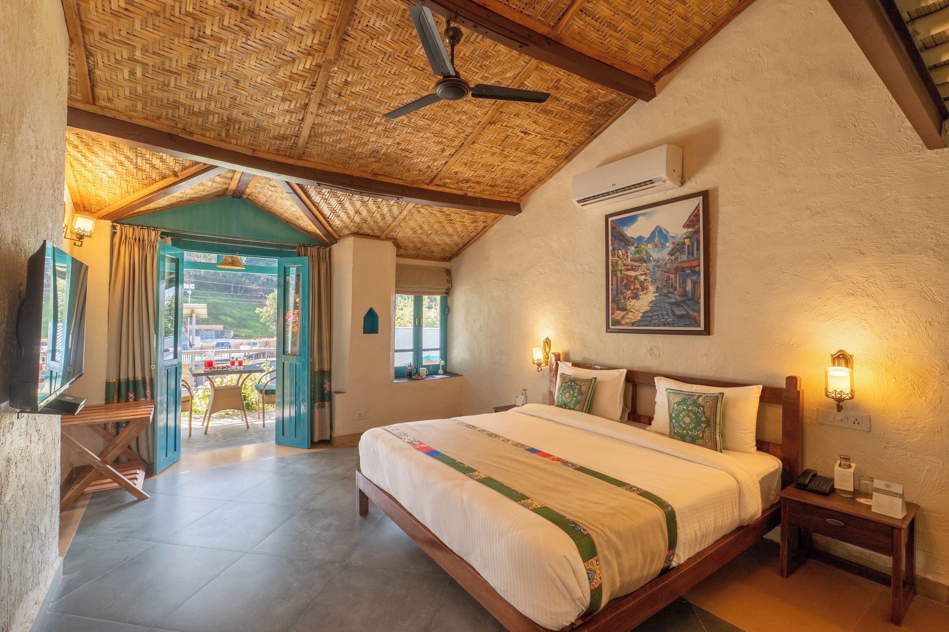 Ein geräumiges Schlafzimmer mit einem großen Bett, einem Deckenventilator und Blick ins Freie.
