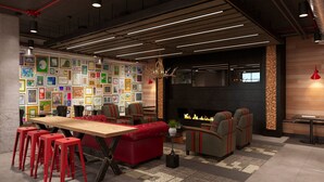 A modern lounge area with a long wooden table, red bar stools, and a fireplace. - Stunning 4-BR Houses with On-Site Pool (Bloomington)