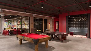A billiards room with a pool table, a ping pong table, and a sofa. - Stunning 4-BR Houses with On-Site Pool (Bloomington)