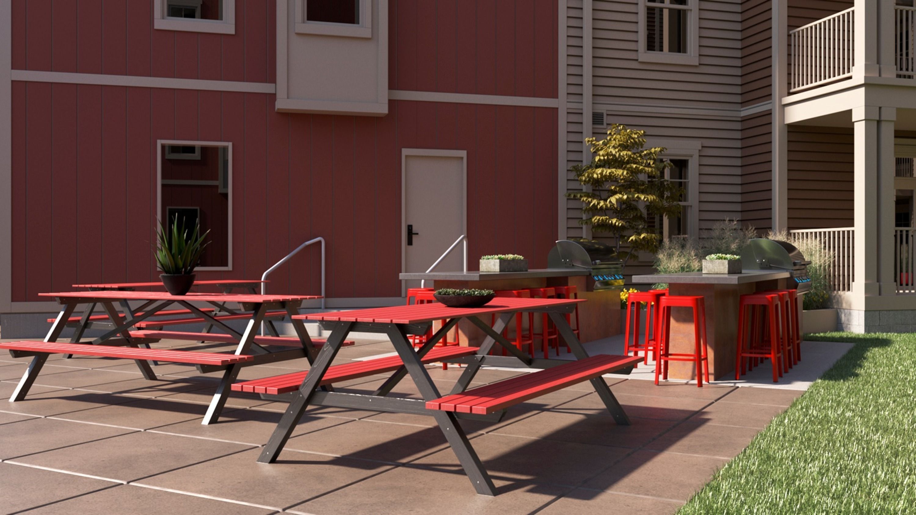 Une terrasse extérieure avec des tables de pique-nique et un espace barbecue.