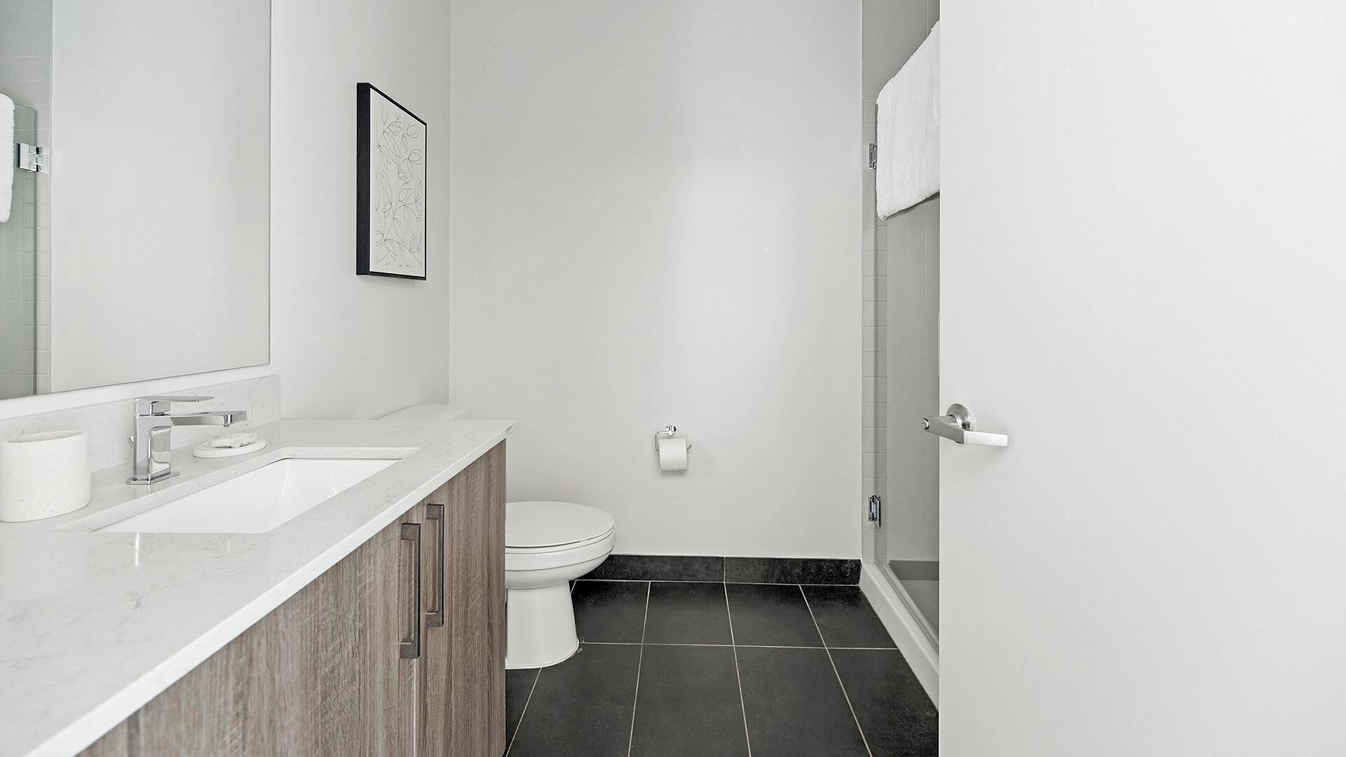 A modern bathroom with two sinks, a toilet, and a shower area.