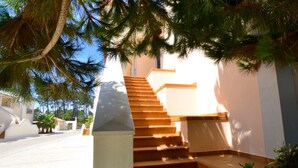 A staircase with a white wall and a stone pillar on the left. - Red House (Amoreira-Óbidos)