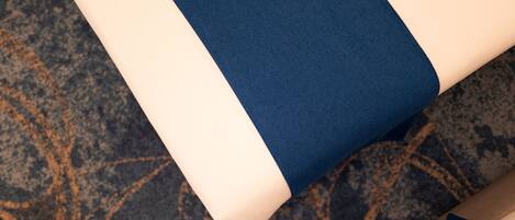 Primer plano de una alfombra con un diseño oscuro y una sección de tela azul y blanca.