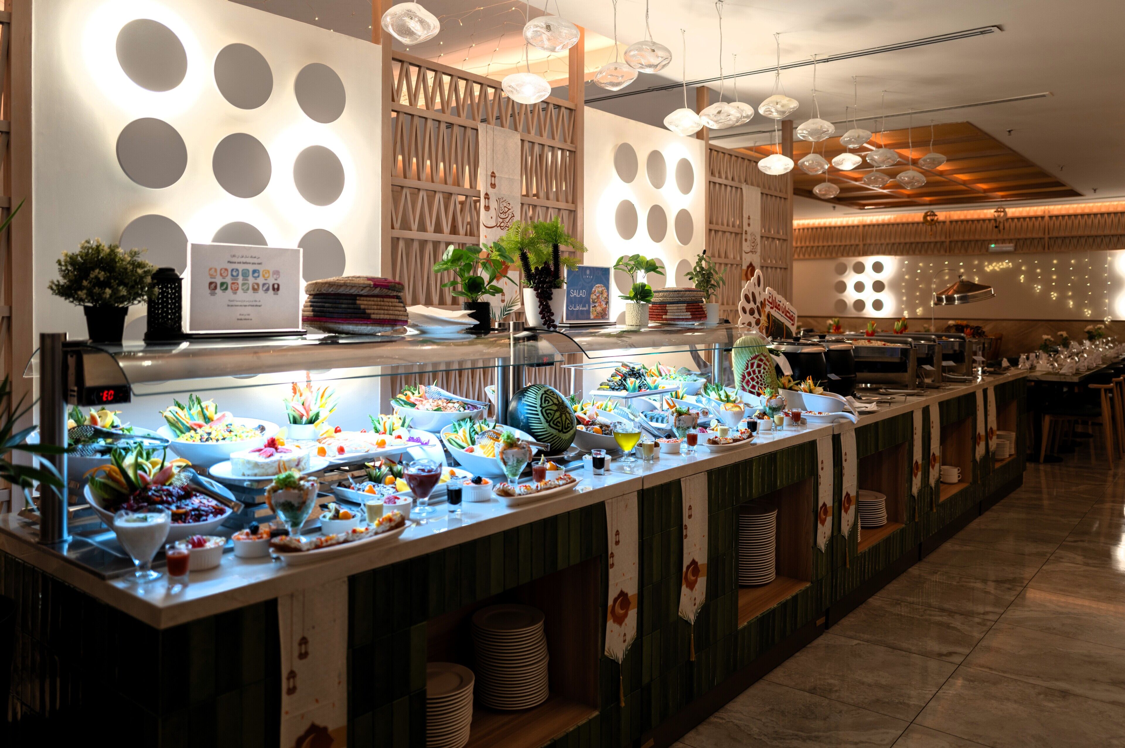 Uma área de buffet com diversos alimentos e um relógio digital mostrando as horas.