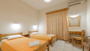 A room with two wooden beds, a desk, and a chair. - Pink Panther Studios & Apartments (Zakynthos)
