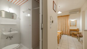 A bathroom with a toilet, sink, and shower. There is a mirror above the sink and a shower curtain. - Pink Panther Studios & Apartments (Zakynthos)
