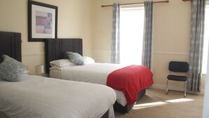 A hotel room with two beds, a chair, and a framed picture on the wall. - No 13 Townhouse (Kilkenny)