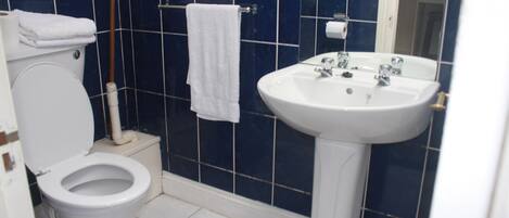 Ein Badezimmer mit Toilette, Waschbecken und Handtuchhalter.