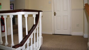 A staircase with white balusters and a wooden handrail, leading to a closed door with a "PRIVATE" sign. - No 13 Townhouse (Kilkenny)
