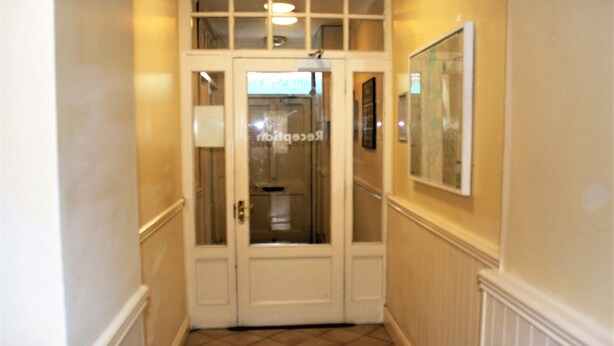 A hallway with a double door, a framed picture on the wall, and a tiled floor. - No 13 Townhouse (Kilkenny)