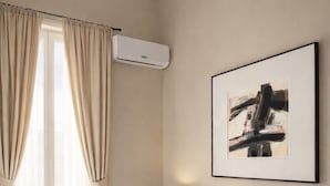 A hotel room with a bed, curtains, an air conditioning unit, a lamp, and a framed abstract painting on the wall. - Bari LandLord 71 (Bari)
