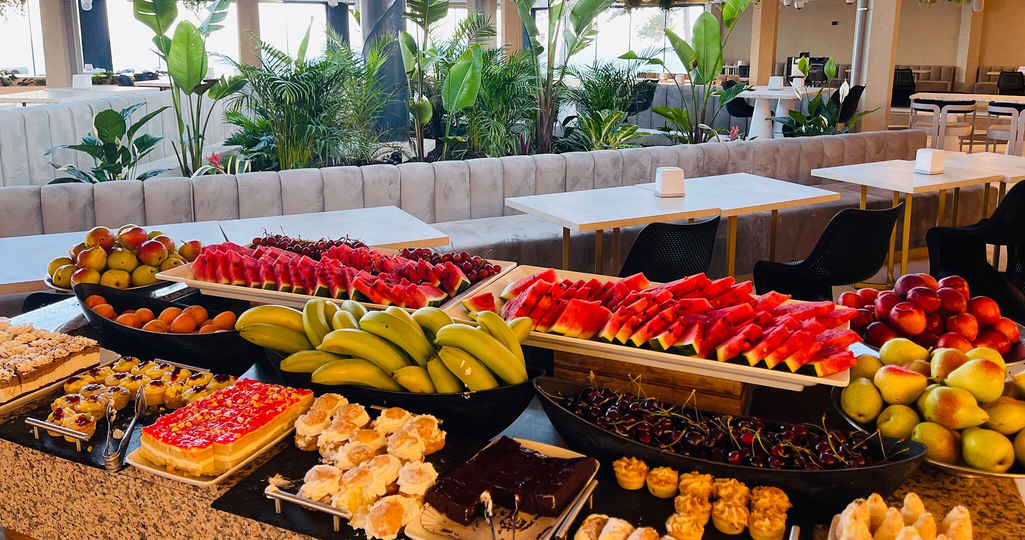 A buffet with various fruits and desserts.