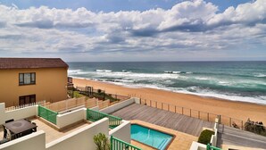 Una propiedad frente a la playa con piscina, patio y vistas al océano.