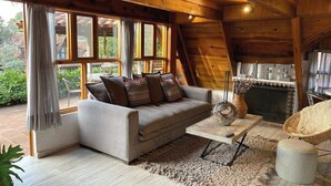 A cozy living room with a sofa, a coffee table, and a fireplace. - Renovated and Harmonious Cabin in Valle de Bravo (Valle de Bravo)