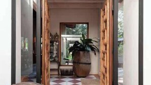 A hallway with a checkered floor, a wooden bench, and a large potted plant. - Spectacular House with Jacuzzi and Huge Garden (San Simón el Alto)