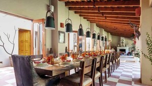 A long dining table with chairs, hanging pendant lights, and a checkered floor. - Spectacular House with Jacuzzi and Huge Garden (San Simón el Alto)