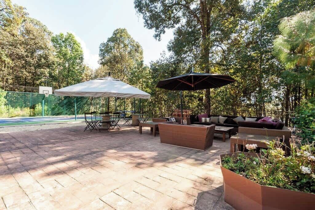 Un espacio de patio al aire libre con mesas, sillas y sombrillas.
