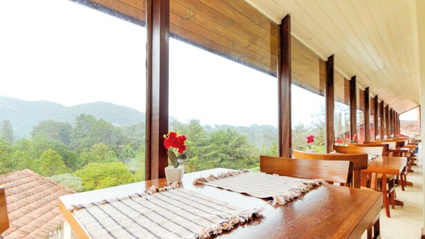 A long dining table with a view of a mountainous landscape through large windows.