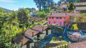 A hillside residential area with houses, a swimming pool, and a staircase leading to a higher level.