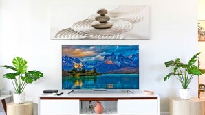 A modern living room with a flat-screen TV mounted on a white entertainment unit. - ZEN Quest · ZEN Quest - 2bed/2bath Near Markets & Foreshore (Nightcliff)