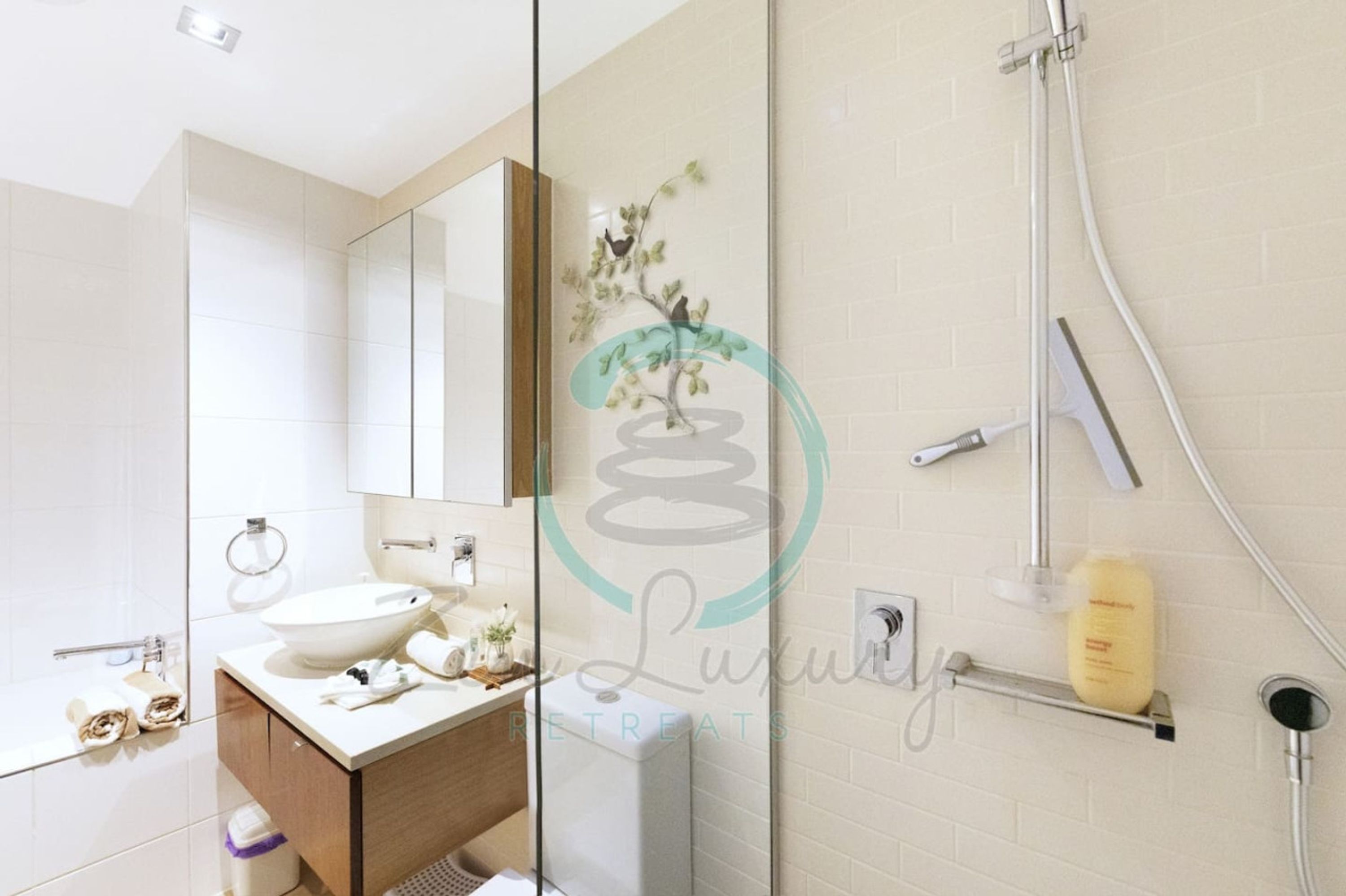 A modern bathroom with a large mirror, a sink, and a shower.