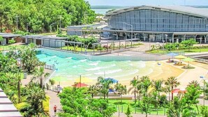 A modern hotel with a large swimming pool, a beach area, and lush greenery. - ZEN Paradise - 2-br Waterfront Ocean View Retreat (Darwin)