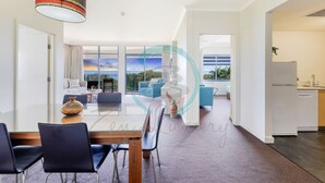 Een moderne hotelkamer met een eetgedeelte, een zithoek met uitzicht en een keuken.