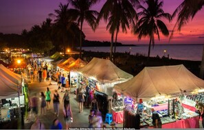 A bustling market with tents and people walking around. - Coastal Elegance Sunset Pool Balcony Dining (Darwin)