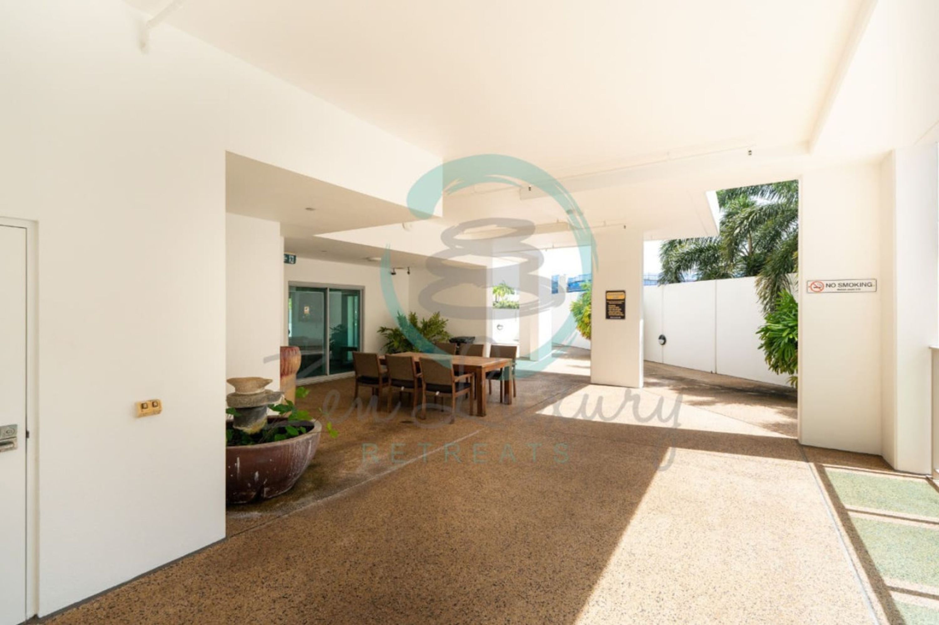 A modern indoor space with a dining area, a no smoking sign, and a view of the outdoors.