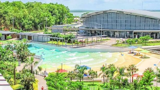 Un hôtel moderne doté d’une grande piscine, d’un espace plage et d’une végétation luxuriante.