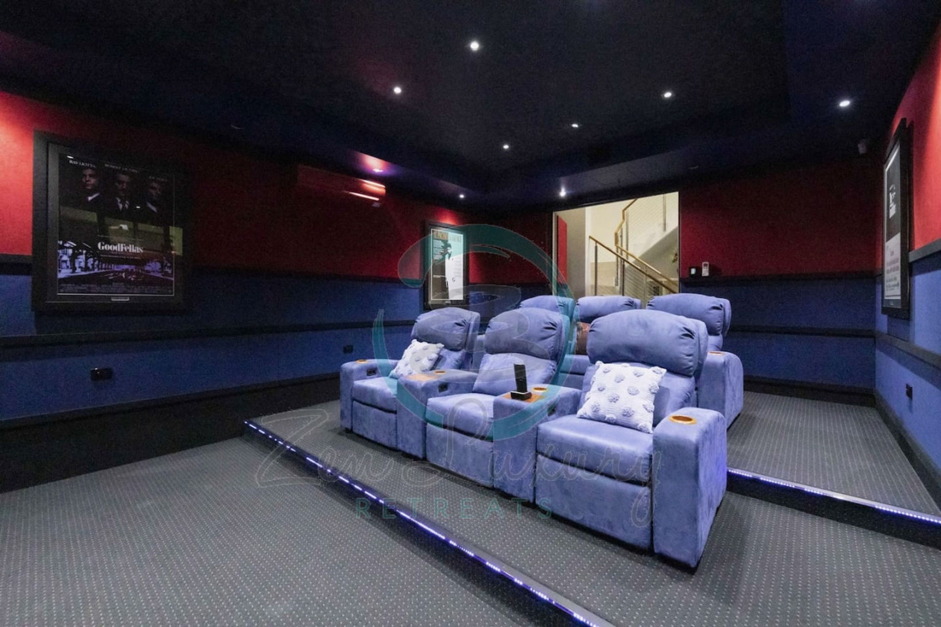 A cinema with a reclining sofa and a screen displaying a movie poster.