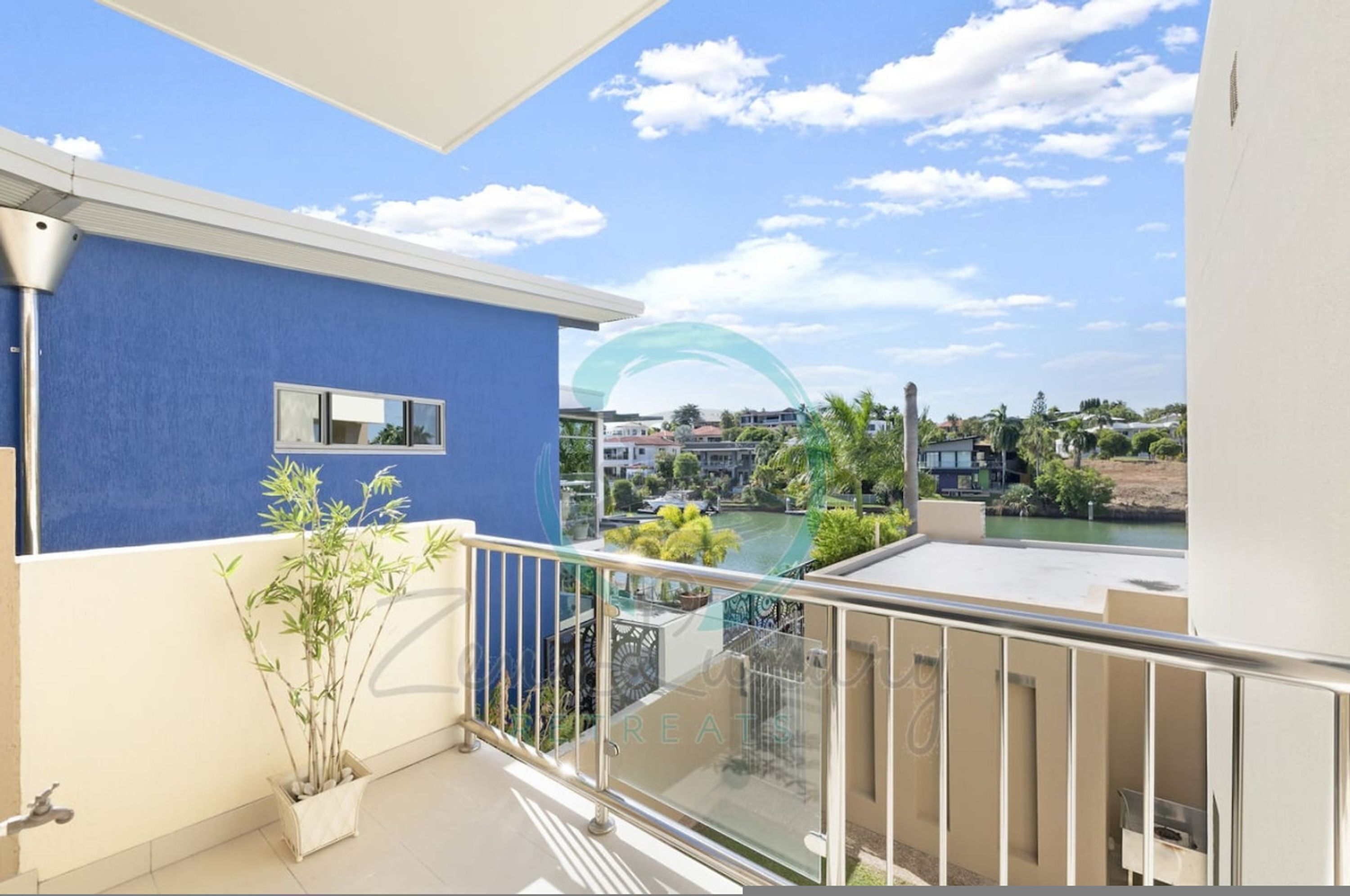 A balcony with a view of a swimming pool and surrounding buildings.