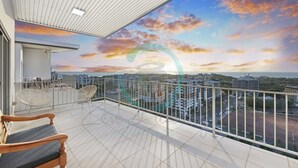 A balcony with a city view, white railing, and a wooden bench. - Pinnacle Penthouse Ambience Views Pool Gym (Darwin)