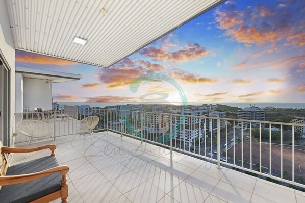 A balcony with a city view, white railing, and a wooden bench. - Pinnacle Penthouse Ambience Views Pool Gym (Darwin)