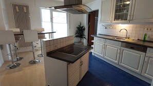 Eine moderne Küche mit weißen Schränken, einer schwarzen Arbeitsplatte und einem blauen Boden.