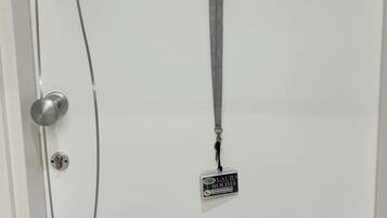 Une porte blanche avec le numéro 3, une serrure et un porte-clés auquel est attaché un badge avec un nom.
