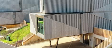 Un bâtiment moderne doté d’un design géométrique original, caractérisé par une structure en porte-à-faux bien visible et un toit incliné.