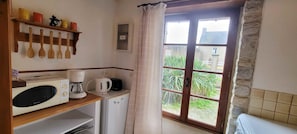 Enjoy a kitchen with microwave, coffee maker, and refrigerator, offering a view of the surrounding greenery.