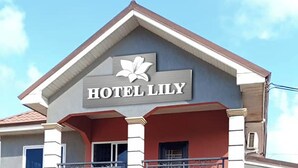 A two-story building with a sign reading "HOTEL LILY" and a flower logo. - Hotel Lily  (Santeo)