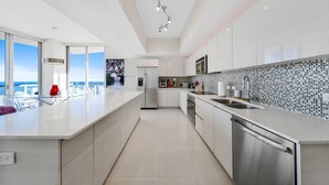 Una cocina moderna con una isla grande, electrodomésticos de acero inoxidable y vistas a la ciudad.