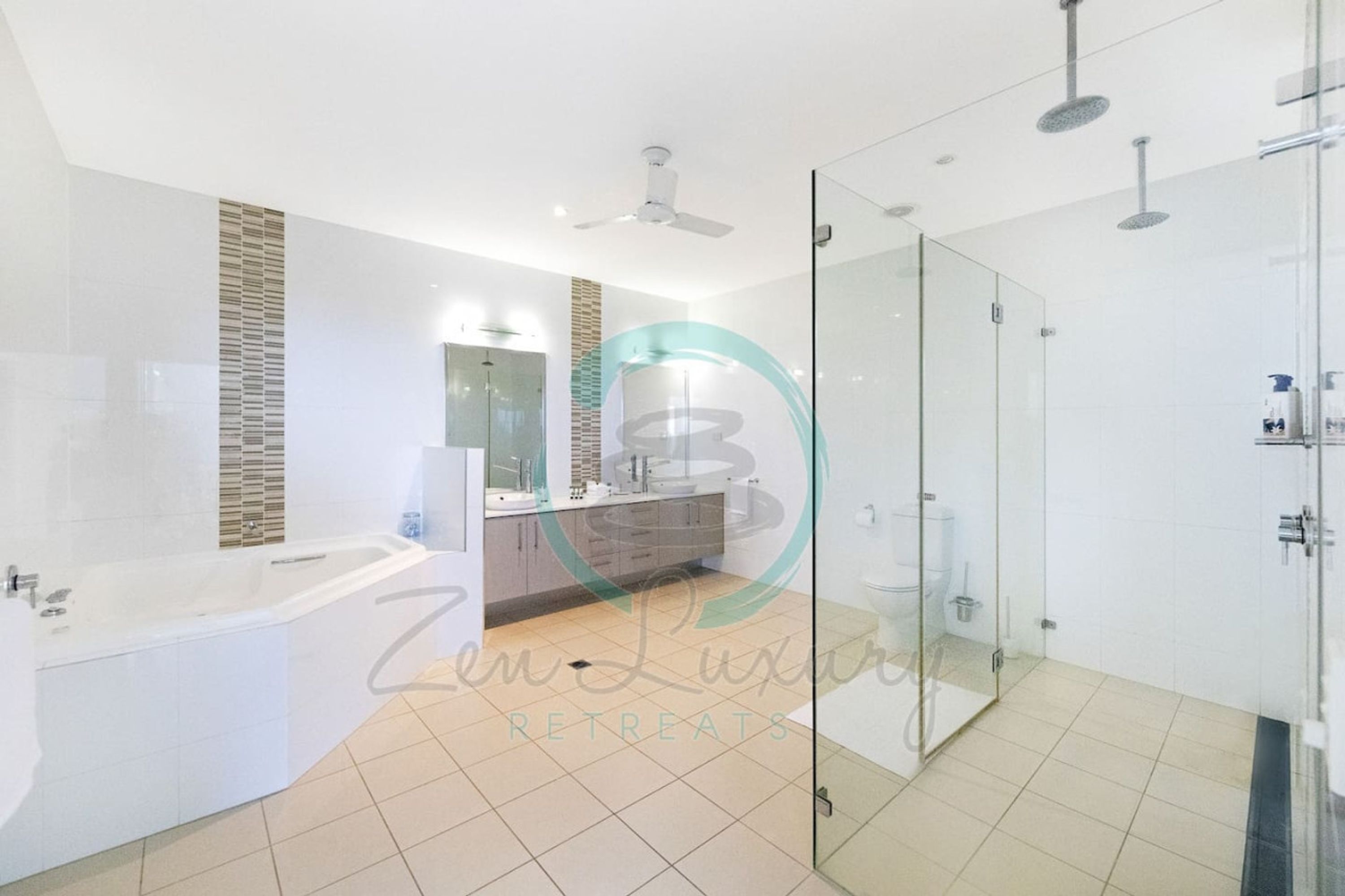 A modern bathroom with a glass shower enclosure, a freestanding bathtub, and a vanity with a mirror.
