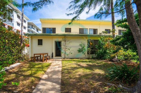 A two-story building with a yellow facade, a small front porch, and a pathway leading to the entrance. - Nightcliff Foreshore Seaview Outdoor Dining (Rapid Creek)