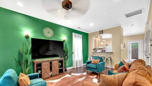 Un salon doté d’un grand téléviseur à écran plat, d’un meuble de rangement en bois et d’un tapis en peau de vache.